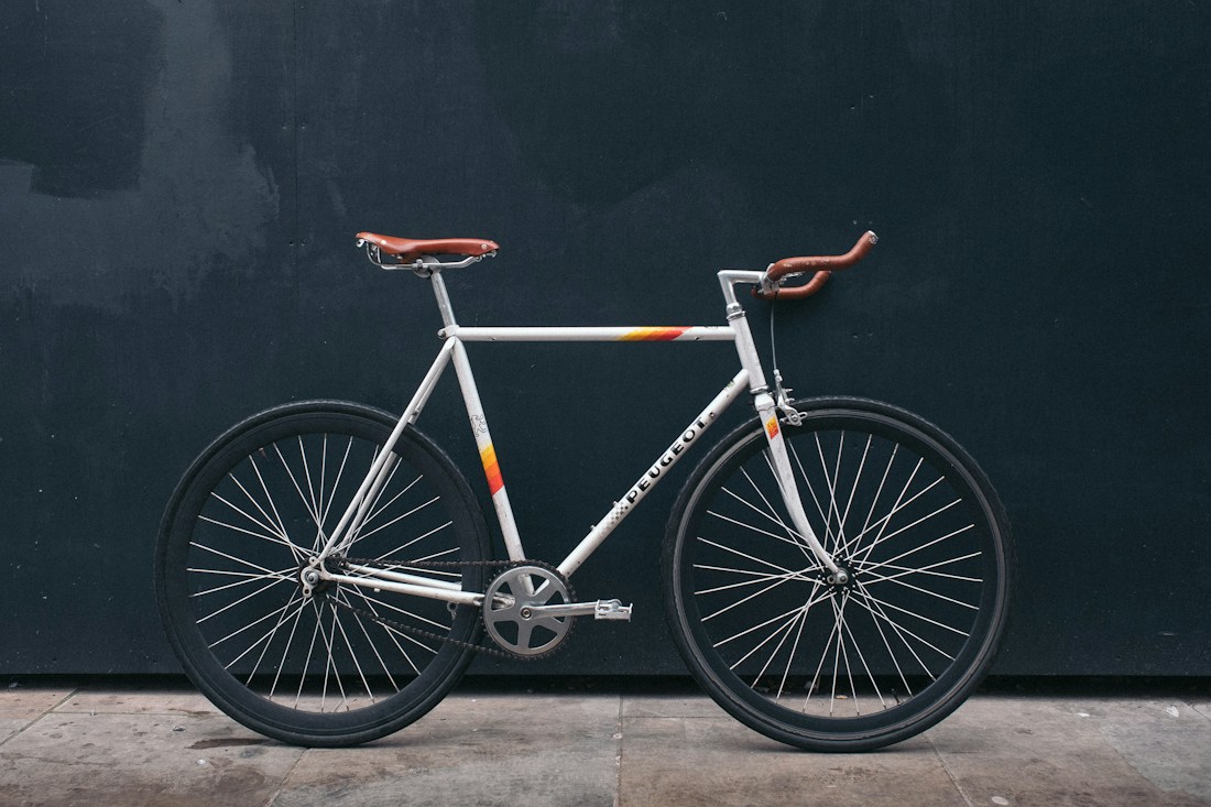 Unattended bicycle leaning against a dark wall